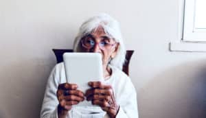 older woman reading tablet (biological age concept)