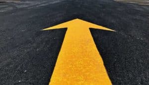 an arrow pointing forward or up in a parking lot