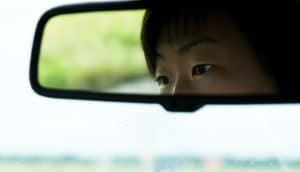 eyes in car's rear-view mirror