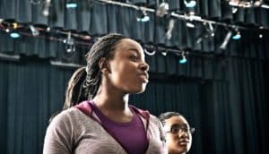 students standing on stage (anxiety concept)