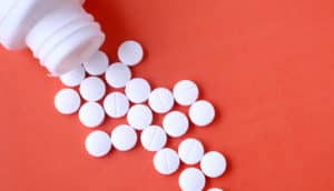 white pills on orangey red (diabetes drugs concept)