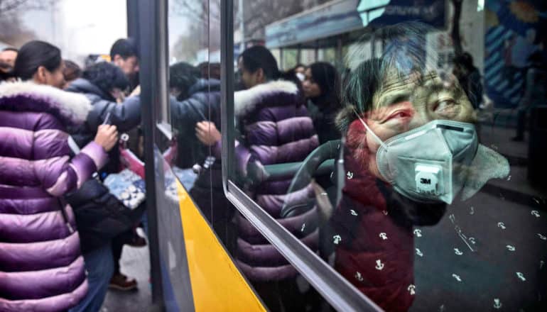 woman on bus wears mask against pollution