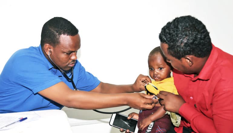 two caregivers and child with cleft palate