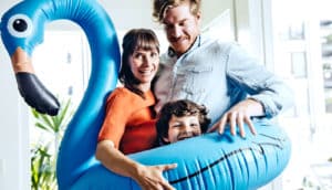 mother father and child within inflatable blue flamingo