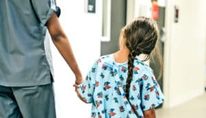 nurse holding child's hand