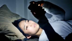 woman in bed with phone