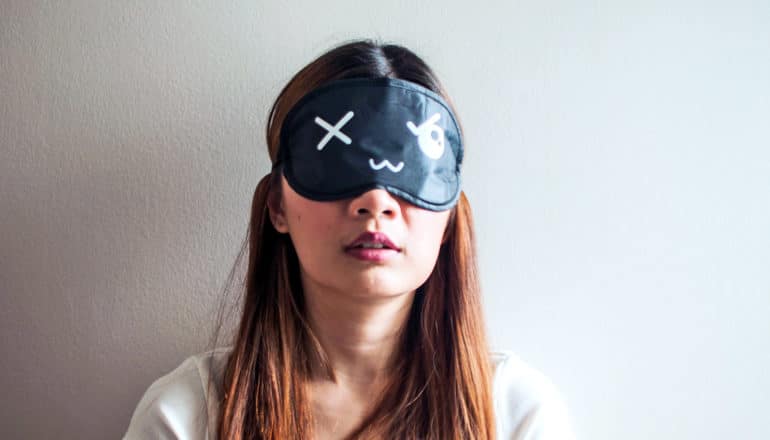 woman wearing sleep mask (insomnia concept)