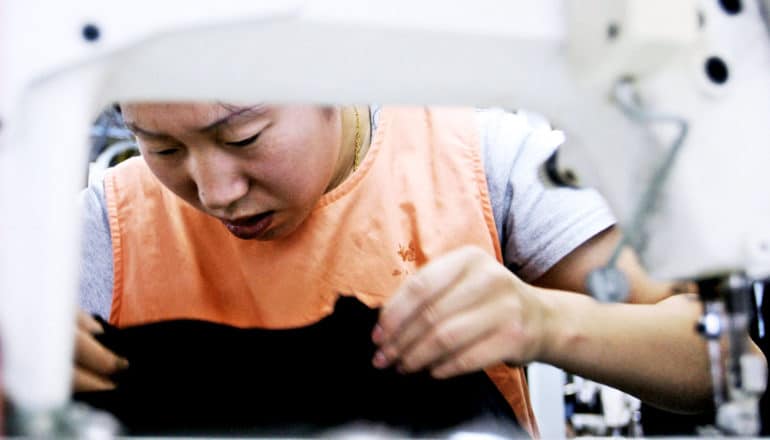 woman behind sewing machine in textile factory