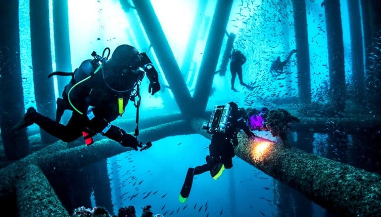 divers in rig reef (oil rigs concept)
