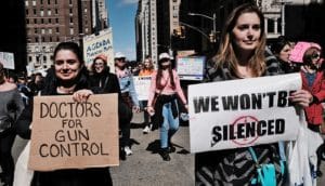 woman holds "doctors for gun control" sign in march