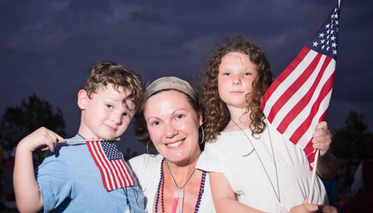 woman and two children with US flags
