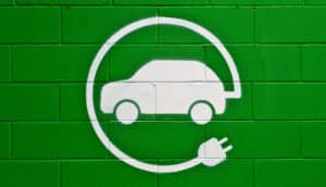 green wall in parking lot with electric car symbol