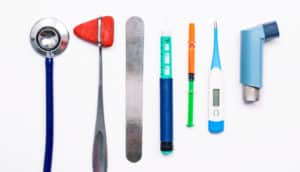 medical tools (stethoscope, tongue depressor, etc.) on white