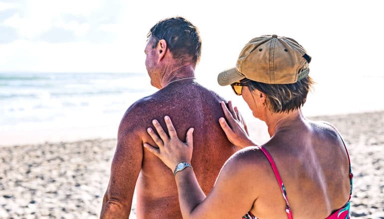 older couple applying sunscreen