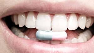 teeth biting down on a pill