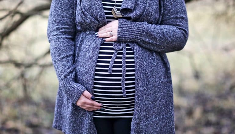 pregnant woman in striped shirt and sweater