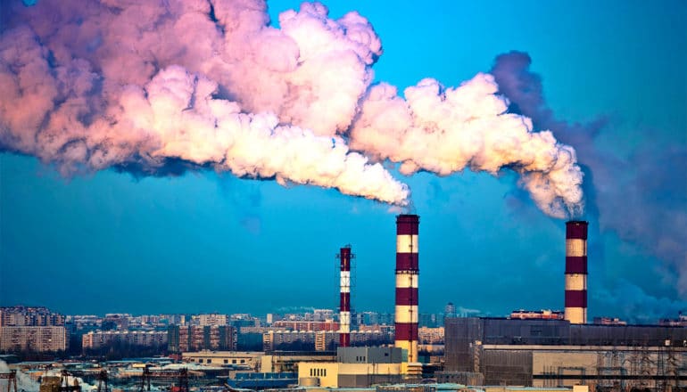 smoke stacks over the city at dusk (coal power concept)