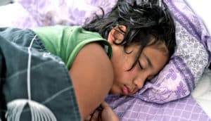 teen girl asleep in bed during day