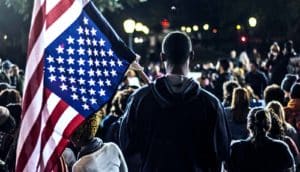 young man holding American flag (millennial voters concept)