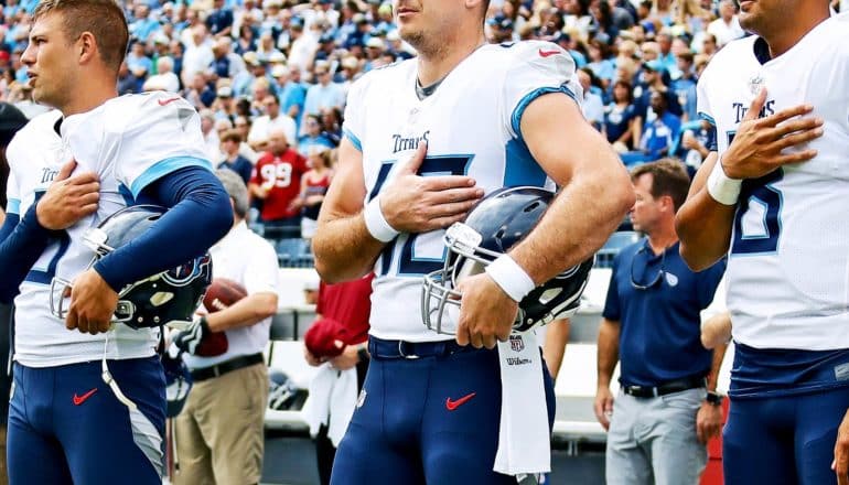 football players with hands over hearts
