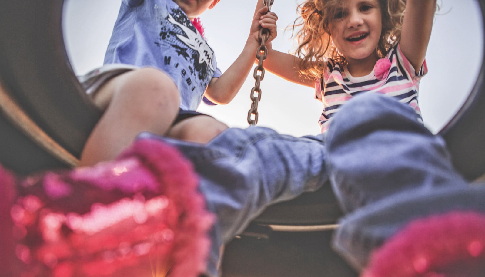 two girls on tire swing from below