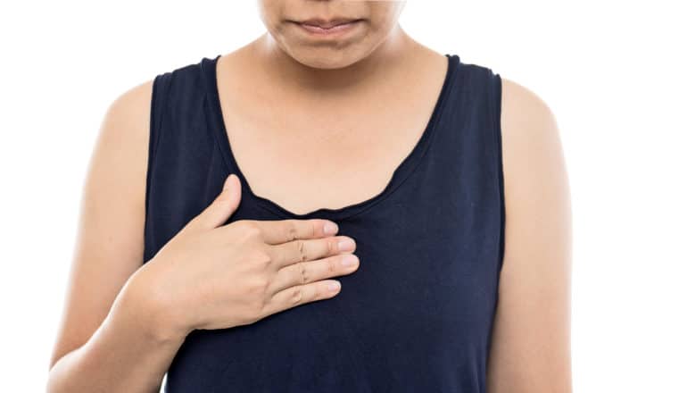 woman with hand on chest -- heartburn