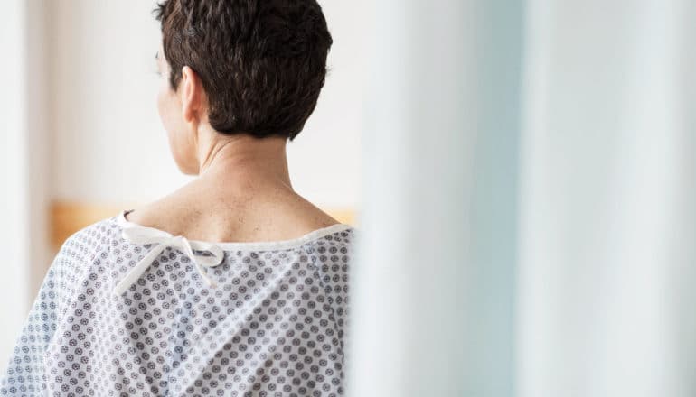 hospital patient in gown facing away