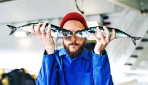 man holding fish up to eyes