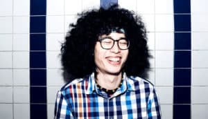 man laughing with tile in the background