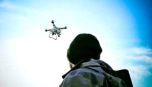 man looking up at drone