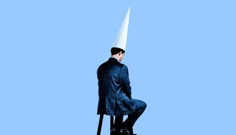 man sitting in dunce hat (artificial intelligence concept)
