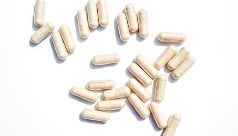 probiotics - beige capsules on white