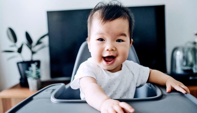 smiling baby in high chair