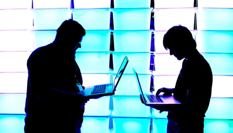 two people with laptops