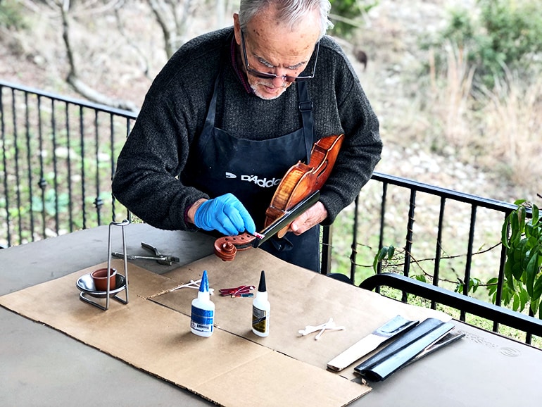 Nagyvary applies glue to a violin fingerboard