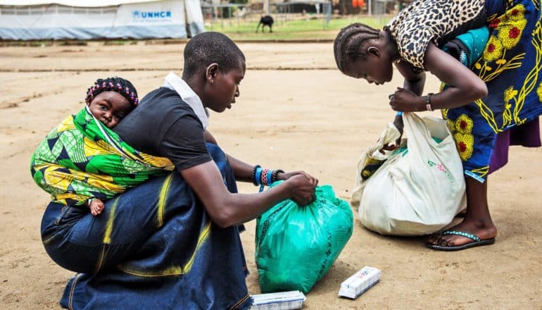 Refugees from the Democratic Republic of Congo prepare to board a bus to the Kagoma reception centre at the UNHCR landing site for refugee arrivals on April 4, 2018 in Sebagoro, Uganda.