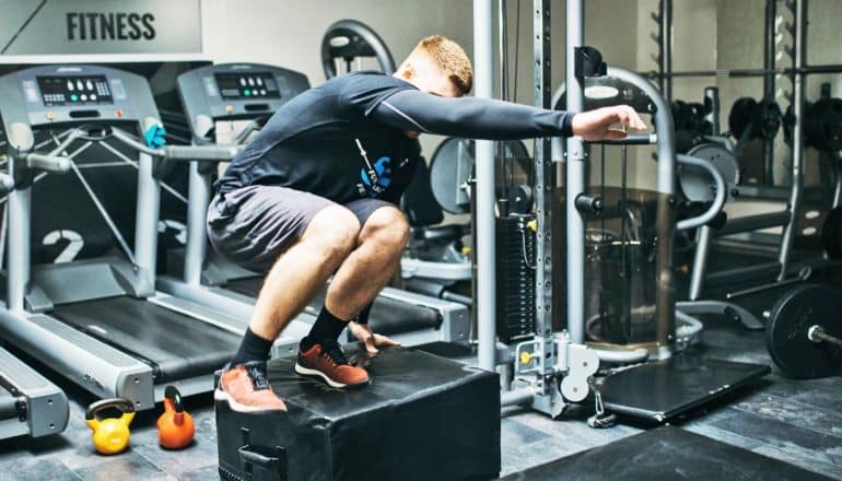 man jumps onto box - high-intensity interval training