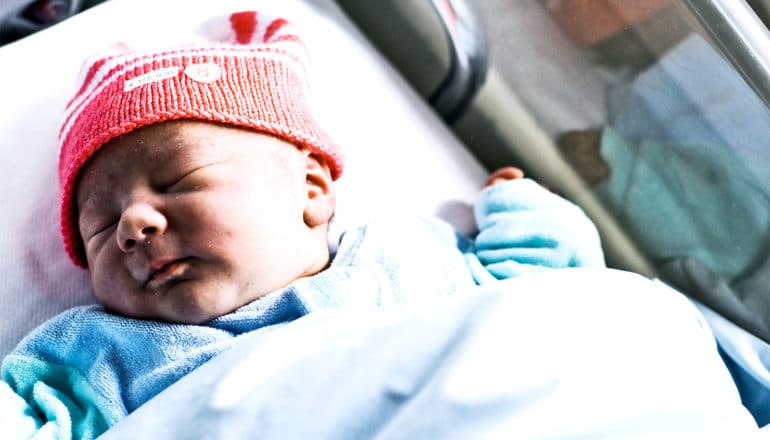 baby in hospital with orange hat