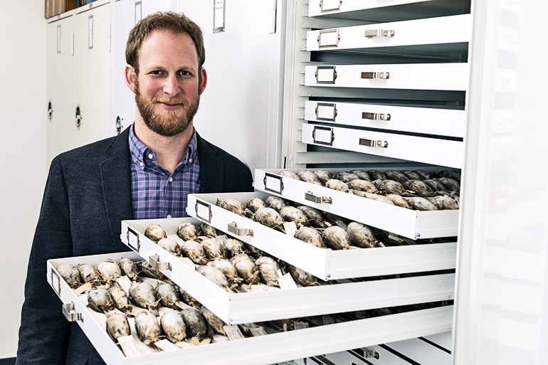 Benjamin Winger with some of the migratory songbirds researchers used in the study