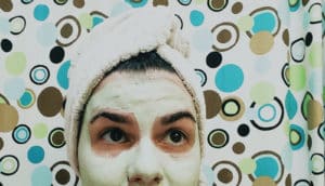 woman with hair in towel and mask on face