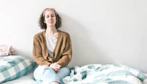 young woman sits on bed - first-year students