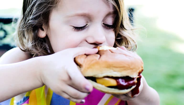 little girl eating burger