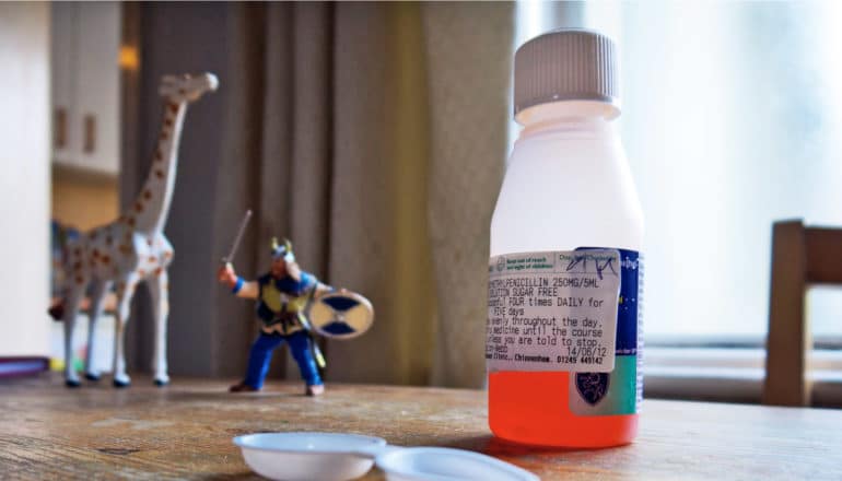 bottle of penicillin and toys on table