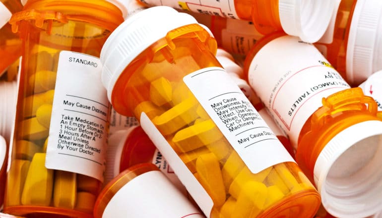 pill bottles piled up (opioid epidemic concept)