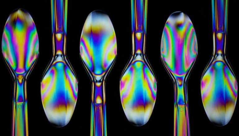 iridescent plastic spoons on black