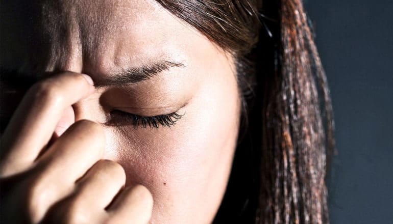 stressed woman with eyes closed (debt relief concept)