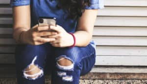 teen girl holding iphone