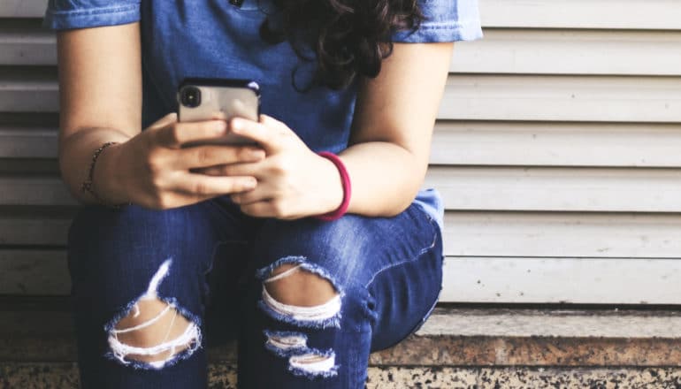 teen girl holding iphone