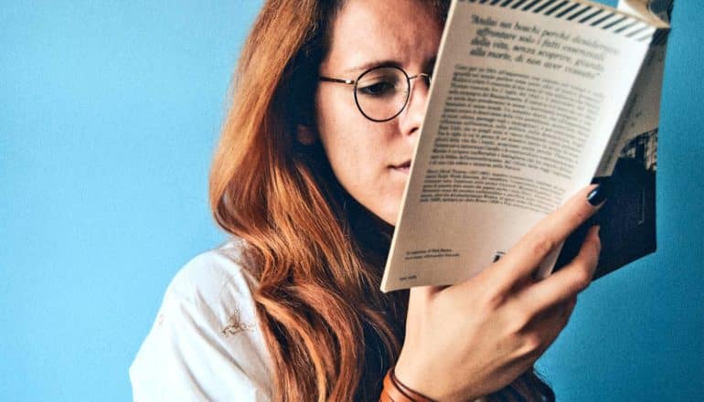 woman reading book against blue (learning speed concept)