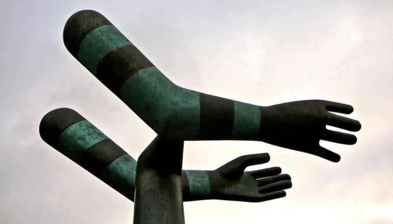 sculpture of extended green and black arms